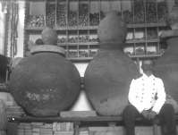 Unknown person sitting in the room of the Warehouse of Local Antiquities with clay barrels, or pithoi