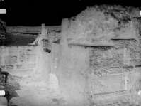 A worker with saw sitting on the ancient tower near the entrance to the citadel