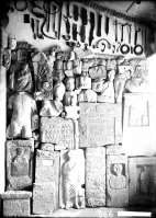 Вид экспозиции: внизу -  каменные надгробия и архитектурные детали, выше на стене музея - железные и бронзовые изделия и под потолком - коллекция глиняных грузил